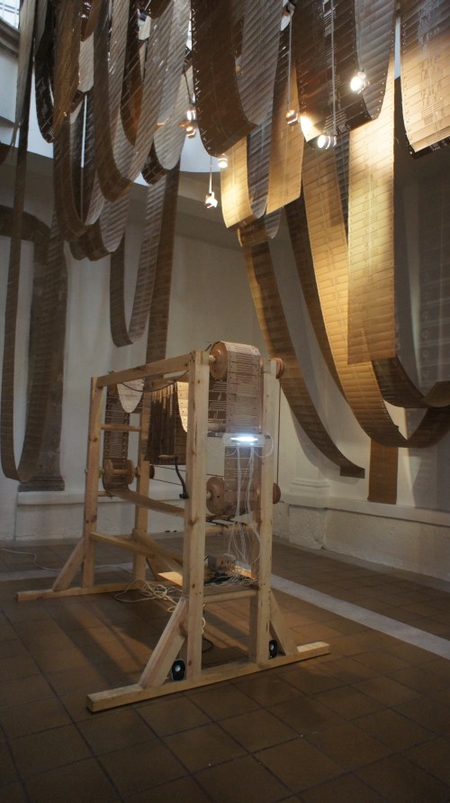 Tania Candiani. Telar/Máquina, 2012 (3). Punched cards, wooden mechanism, optical tone generator, speakers, drawings, single channel video and embroidered strips. 2.40 x 2.00 x 1.10 m. Courtesy of the artist and Instituto de Visión.
