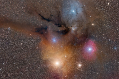 DEEP SPACE. Runner Up: Tom O’Donoghue (Ireland), Rho Ophiuchi and Antares Nebulae. The smoky appearance of the dust clouds in this image is fitting, since the grains of dust which make up the nebula are similar in size to particles of smoke here on Earth. The dust can reflect the light of nearby stars, as seen in the blue and yellow regions. It can also block and absorb the light of more distant stars, appearing brown and black in this image. To the right a bright star is ionizing a cloud of hydrogen gas, causing it to glow red, while below it far in the distance, is a globular cluster containing thousands of stars. © Tom O’Donoghue.