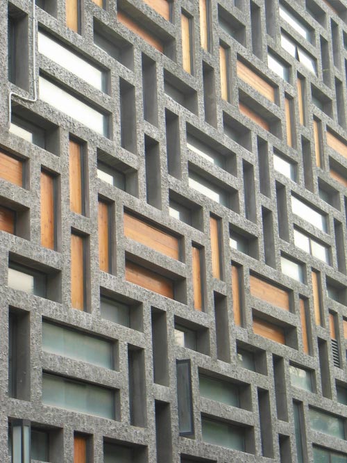 The interplay of glass, timber and openings among the textured concrete ‘Mondrianese’ grid at the rear elevation of the building.