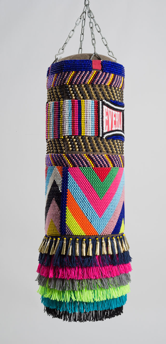 Jeffrey Gibson. This Is Our House, 2014. Found vinyl punching bag, glass and plastic beads, artificial sinew, brass and steel studs, wool military blanket, acrylic yarn, steel chain, 42 x 14 x 14 in. Image courtesy of Jeffrey Gibson Studio. Photograph: Peter Mauney.