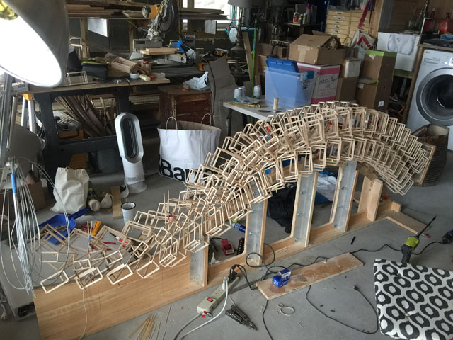 Basswood maquette for Lanchals, cradled horizontally on its jig, built in John Powers' workspace in New York. Image courtesy John Powers.