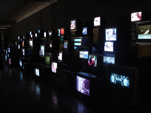 Douglas Gordon. Pretty Much Every Film and Video Work From about 1992 Until Now to be Seen on Monitors, Some with Headphones, Others Run Silently, and all Simultaneously, 1992–. Installation view.