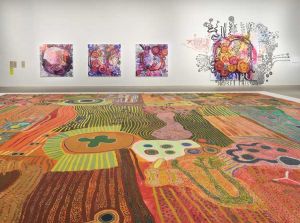Foreground: Ngurrara Artists, Ngurrara Canvas II, 1997. Courtesy of the artists and the Ngurrara Canvas Management Group (NCMG) © Ngurrara Artists. Background: Yaritji Young, Tjala Tjukurpa III, 2025; Tjala Tjukurpa II, 2025; Tjala Tjukurpa IV, 2025; Tjala Tjukurpa I, 2025; Tjala Tjukurpa, 2026., 2026. Courtesy of the artist and Tjala Arts © Yaritji Young. Installation view, 25th Biennale of Sydney, Rememory, 2026, Art Gallery of New South Wales. Photo © Art Gallery of New South Wales, Felicity Jenkins.