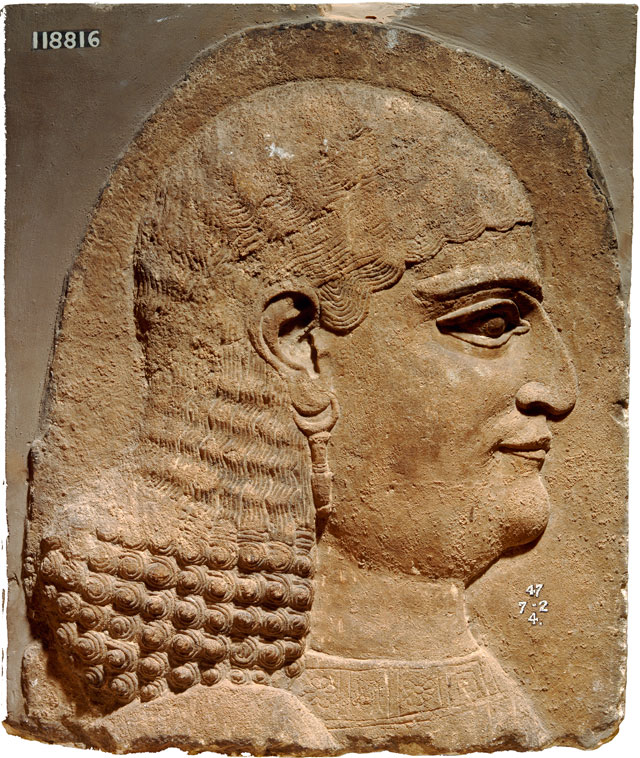 Fragment of a wall panel showing the head of a eunuch. Khorsabad, Iraq 710 – 705 BC. © the Trustees of the British Museum.