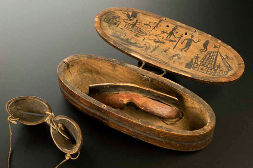 R for RESOURCEFULNESS. Inuit snow goggles and wooden case decorated with hunting scenes. Carved wood and rawhide, 19th century © Science Museum/Wellcome Collection. Goggles such as these were invented by the Inuit people of North America about 2,000 years ago to protect wearers against snow blindness.