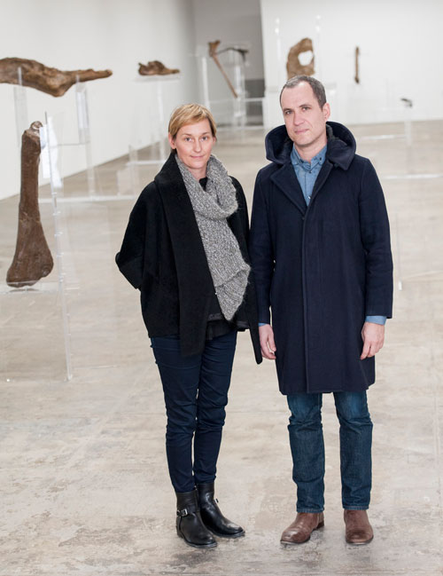 Allora & Calzadilla. Portrait of the artists. Background: Intervals, 2014. Re-configured acrylic
lecterns and dinosaur bones. Dimensions variable. Courtesy of the artists. In collaboration with
The Fabric Workshop and Museum, Philadelphia. Photograph: Constance Mensch.