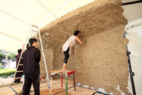 Anindita Dutta. Doroing (Doro - clay in Japanese). Applying the clay to the stage backdrop. Courtesy Anindita Dutta.