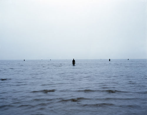 Antony Gormley. <em>Another Place</em>, 1997. Cast iron, 189 x 53 x 29 cm (100 elements). Installation view, Cuxhaven, Germany. © Antony Gormley. Photograph by Helmut Kunde.