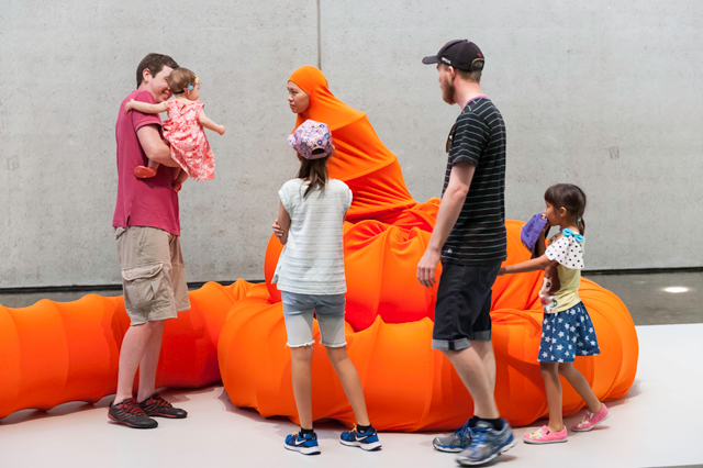 Anida Yoeu Ali. The Buddhist Bug, 2015. Orange lycra, wire, tube, thread, glue and two live bodies. Performance for The 8th Asia Pacific Triennial of Contemporary Art, Gallery of Modern Art, Brisbane, 21–22 November 2015. Courtesy: The artist.