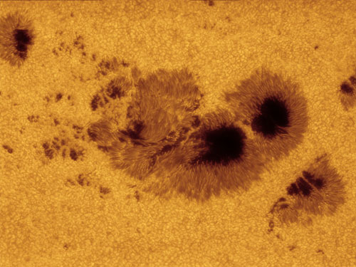 OUR SOLAR SYSTEM. Runner Up: Alan Friedman (USA), Magnetic Maelstrom. The darkest patches or ‘umbrae’ in this image are each about the size of Earth, with the entire region of magnetic turmoil spanning the diameter of ten Earths. This image captures rich details directly around the sunspots, and further out in the so-called ‘quiet’ Sun where simmering hot plasma rises, cools and falls back. This produces a patchwork surface like a pot of boiling water, but on an epic scale – each bubbling granule is about the size of France. © Alan Friedman.