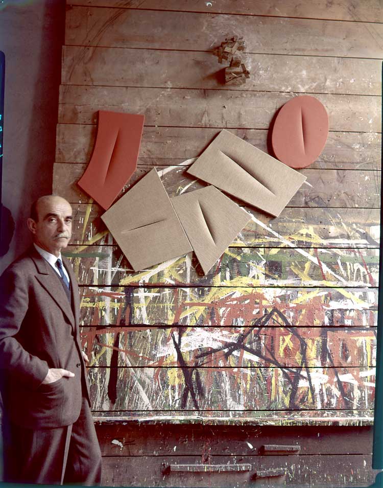 Lucio Fontana with works from the Quanta series, 1959. © Fondazione Lucio Fontana by SIAE 2019. Courtesy Fondazione Lucio Fontana, Milano.