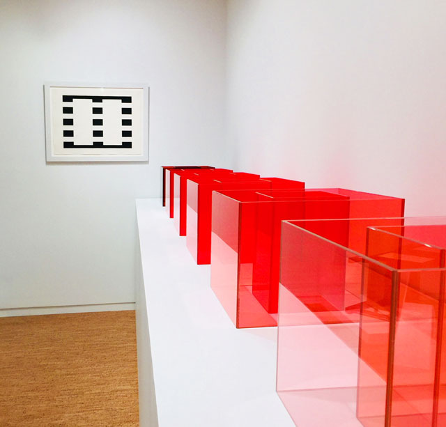 John Mclaughlin, JMD-3, 1962. Oil on paper; Larry Bell, Pacific Red, 2017 (detail). Red laminated glass, installation view, The Bunker Artspace, West Palm Beach, Florida. Photo: Jill Spalding.
