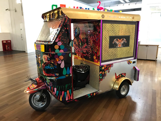 Chila Kumari Burman. My Valiant Queen Tuk Tuk, 2017-18. Mirror glass, plastic eyelashes, fabric, rhinestones, Swarovski gems, washi tape, rakhis, bindis, Columbo gems, wrapping paper, gold spray paint, stickers, fake gems, fairy lights, Christmas decorations, feather flamingo, wood, plastic, stickers, satin tassels, paper flowers.