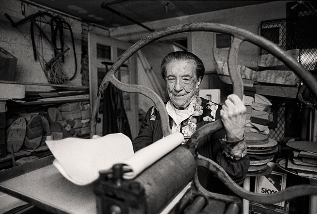 Louise Bourgeois at the printing press in the lower level of her home/studio on 20th Street, New York, 1995. Photograph by and © Mathias Johansson.