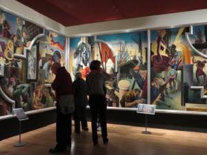 Museum visitors viewing panels of America Today (left to right): City Activities with Dance Hall, City Building, and Steel. Each: distemper and egg tempera on gessoed linen with oil glaze.