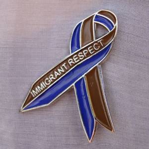 Tania Bruguera. Awareness Ribbon for Immigrant Respect Campaign, 2011.  Awareness campaign. Metal pins, community meetings, letters sent to elected officials, media. Photograph: Camilo Godoy Courtesy of Immigrant Movement International (web).