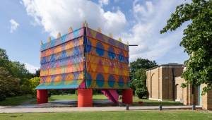 The Colour Palace is a monumental temporary pavilion by artist Yinka Ilori and architects Pricegore, bringing the heat and vibrant hues of Nigerian markets and mosques to the Sir John Soane-designed Dulwich Picture Gallery. But does it do more than simply draw attention and add ornament?