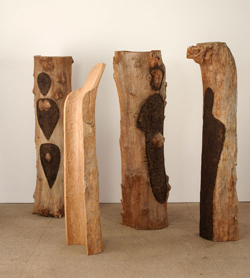 Ana Mendieta. Totem Grove 1983-85. Four semicircular tree trunks carved and burnt gunpowder. Estate Mendieta.