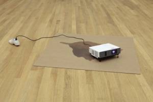 Paul Chan. Die All Jennies 1, 2013. Cardboard, concrete, cord, shoe, video projector with digital colour video, silent, 17.8 x 212.1 x 130.8 cm overall.