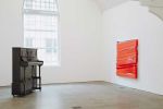 Angela de la Cruz, Upright Piano, 1999 (left), and Shutter (Red), 2017. Installation view, UPRIGHT, Ikon Gallery, Birmingham, 2026. Image courtesy Ikon. Photo: Tom Bird.