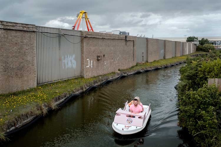 A couple in a pleasure boat ride along the exterior of Pleasure Beach, Skegness, July 2019. "I found it remarkable that someone would pay money to sit in a boat that goes along a ride with no view." – Merlin Daleman.