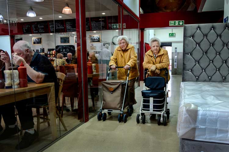 Two ladies stand in a shopping centre in Romford, June 2018. "69.7% voted for Brexit in the London borough of Havering, England." – Merlin Daleman.