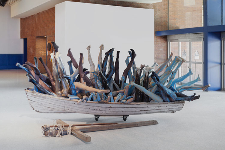 Abigail DeVille. Sarcophagus Blue​, 2017. Boat, mannequin legs, nylon stockings, wood, rope, paint, 132 x 48 x 36 inches. Installed at The Armory Show, New York. Courtesy the artist. Photo: Abigail DeVille.