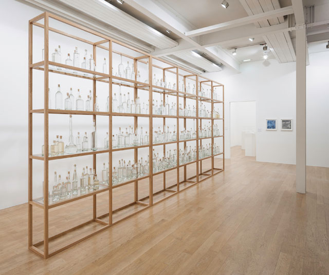 Tania Kovats. All the Sea, 2012-14. Seawater, glass, cork, oak (365 bottles), 600 x 278.5 x 40 cm (236.2 x 109.6 x 15.7 in). Installation view, Oceans, solo exhibition, The Fruitmarket Gallery, Edinburgh 2014. Courtesy the artist and Pippy Houldsworth Gallery, London. Photograph: Ruth Clark.