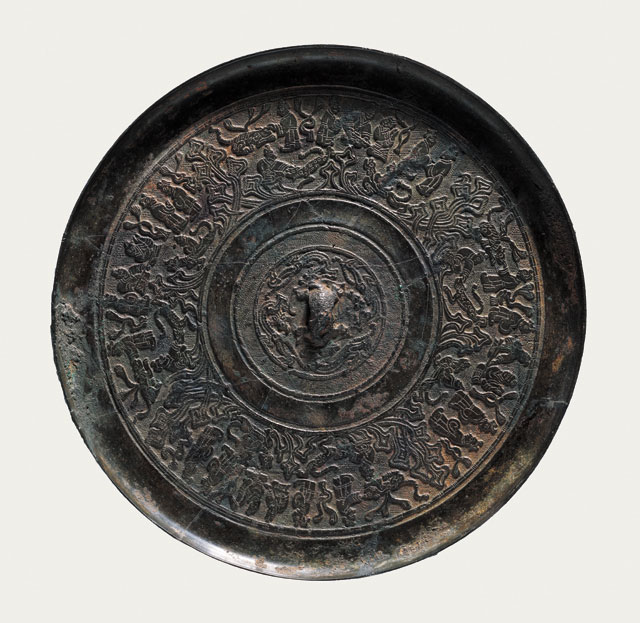 Bronze mirror with portrayals of people, Western Han (206 BCE – 8 CE), Diameter 18.6 cm (7 3/8 in), T (at edge) 0.9 cm (3/8 in), excavated in 1994 from the Marquis of Wanqu’s tomb at Bojishan. Collection of the Xuzhou Museum. 人物画像铜镜，西汉，直径18.6、缘厚0.9厘米，1994年簸箕山宛朐侯墓出土，徐州博物馆藏