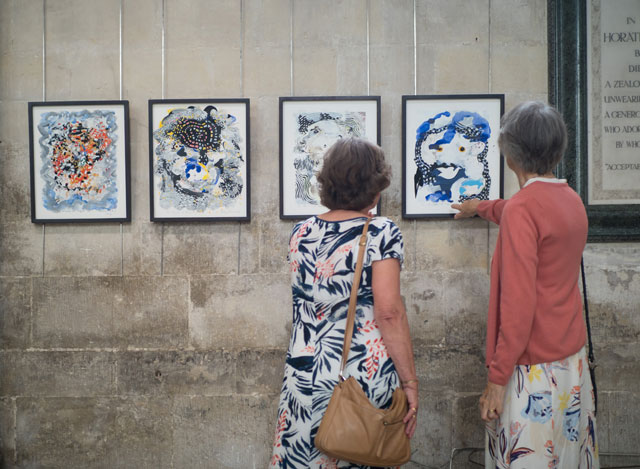 Visitors explore the four works on paper. The Miracle of Birth by Stephen Farthing RA. Installation view, Salisbury Cathedral. Photo: Ash Mills.