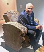 Frank Gehry sitting in one of the cardboard armchairs he designed. Photo: Ann Philbin.
