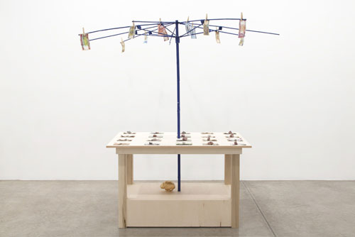 Meschac Gaba. Bureau d'échange [Exchange Office]: Cotton, 2014. Wood table, metal umbrella frame, assorted banknotes, clothespins, cotton stocks, overall; 84 x 80 x 80 in 213 x 203 x 203 cm.