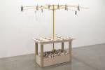 Meschac Gaba. Bureau d'échange [Exchange Office]: Brain, Stone, 2014. Wood table, metal umbrella frame, assorted banknotes, clothespins, electroplated gold brain, rocks and brick pieces, overall; 84 x 80 x 80 in 213 x 203 x 203 cm.