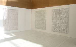 Reni Gower/Tamin Sahebzada. Installation view: (left to right) Papercuts: White/copper, Papercuts: White/emerald, Papercuts: White/cobalt, 81 x 56 in each, and Tamim Sahebzada, Wall tracing 60 x 10 in.