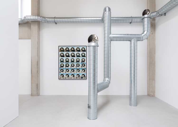 Nancy Holt, Sun Tunnels: Shifting Shadows, 1976, composite inkjet print on archival rag paper. Ventilation Systems, 1985-92  (detail), steel ducts, turbine ventilators, shanty caps, fans, air. Installation view, Nancy Holt, MoonSunStarEarthSkyWater, Goodwood Art Foundation, 2026. Artwork © Holt/Smithson Foundation / Licensed by Artists Rights Society, New York. Photo: Lucy Dawkins / Courtesy Goodwood Art Foundation.