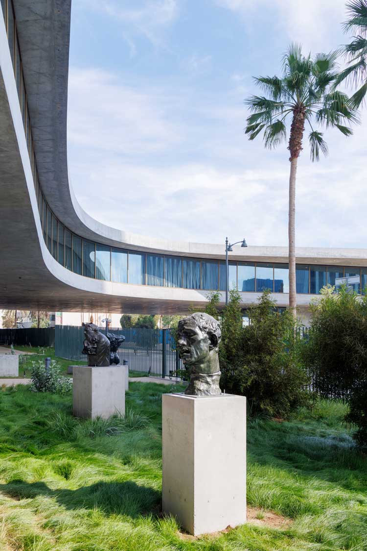 Iris and B. Gerald Cantor Sculpture Garden with Auguste Rodin’s Monumental Head of Pierre de Wissant (1884–85) in foreground, David Geffen Galleries at LACM. Photo © Iwan Baan.