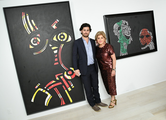 Leila and Alexander Heller in front of Keith Haring paintings at their uptown gallery.