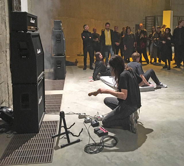 Eliza Douglas playing a guitar, Anne Imhof: Sex at Tate Modern 2019. Photo: Veronica Simpson.