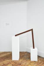 Iman Issa. Surrealism III (study for 2014). Mahogany sculpture, text panel under glass and two white plinths. Sculpture 79.6 x 75 x 5 cm; small plinth 45 x 25 x 25 cm; large plinth 93.3 x 25 x 25 cm, 2014.