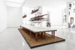 Remy Jungerman. Visiting Deities, 2018-19. Cotton textile, kaolin, dry river clay, water samples, painted wood, 58 table legs (meranti), yarn, mirror and nails, 384 x 138 x 102 in (975 x 350 x 260 cm). Photo: Aatjan Renders.