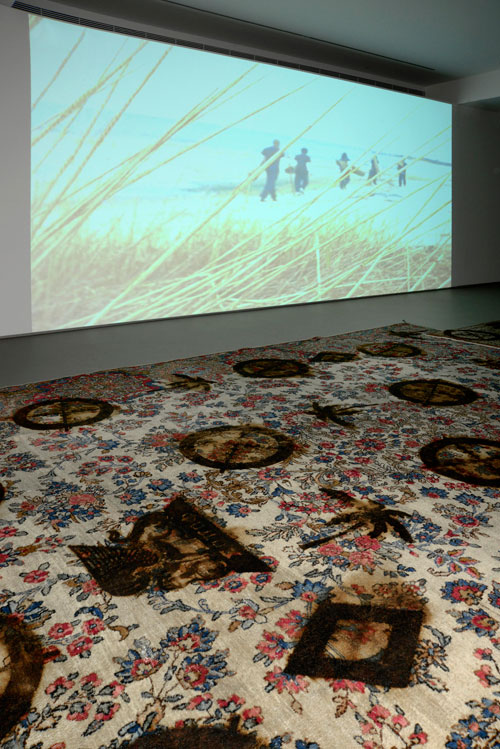 Rashid Johnson. The New Black Yoga Installation, 2011. 16mm film transferred to DVD, sound, 10 minutes 57 seconds. Branded Persian rugs, 27.9 x 35.6m. © Rashid Johnson. Courtesy the artist and Hauser & Wirth. Photograph: Rebecca Constantopoulou and Fanis Vlastaras.