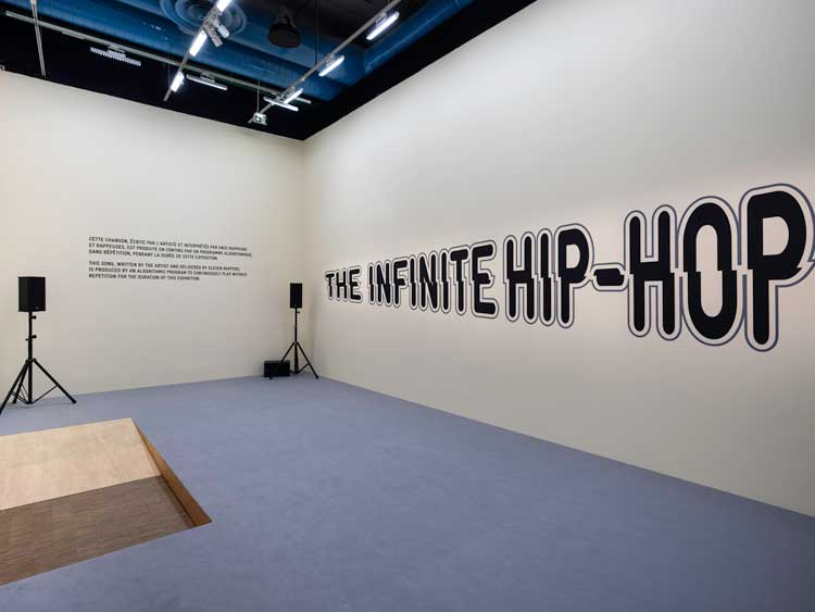 Hassan Khan. The Infinite Hip-Hop Song, 2019. Algorithmic hip-hop generator, original lyrical and musical material written and produced by the artist, recorded vocal content, wall text and painted logo, sound system, variable dimensions. Photo: © Centre Pompidou – hélène Mauri.