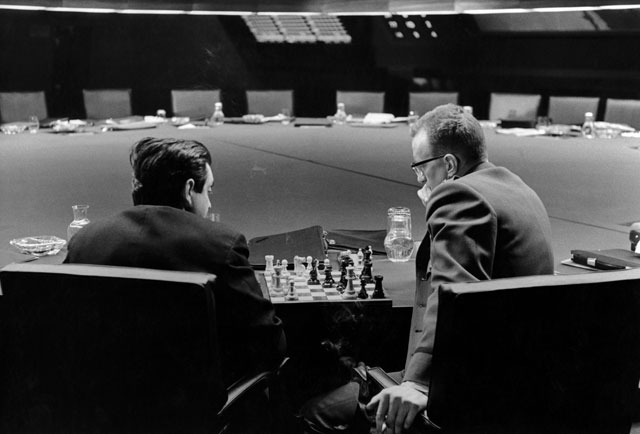Stanley Kubrick and George C. Scott playing chess in the War Room, in a break during filming of Dr. Strangelove or: How I Learned to Stop Worrying and Love the Bomb, directed by Stanley Kubrick (1963-64; GB/United States). Production photo. © Sony/Columbia Pictures Industries Inc.