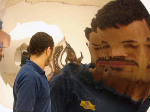 A visitor observes Anish Kapoor's <em>Double Mirror</em> at 'Ascension'. Double Mirror, 1998, stainless steel, two parts, 200 x 200 cm (each)