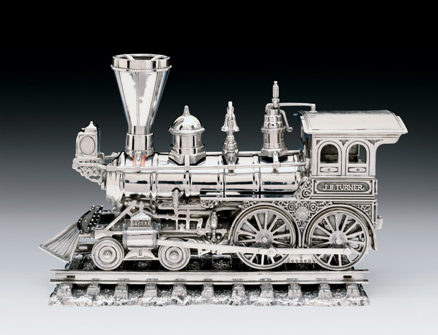 Jeff Koons. Jim Beam - J.B. Turner Engine, 1986. Stainless steel, bourbon, 11 x 17 x 6 1/2 in (27.9 x 43.2 x 16.5 cm). Edition of 3 plus AP. © Jeff Koons.