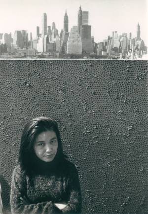 Yayoi Kusama with net painting and skyline in New York, c1961.