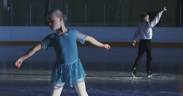 Liz Magic Laser. Kiss and Cry, 2015. Single-channel 4K video, 13 min 30 sec, video still (4). Featuring figure skaters Anna MacKenzie and Axel MacKenzie and coach Marie Jonsson MacKenzie. Commissioned and produced by Mercer Union.