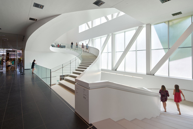 Pierre Lassonde Pavilion, Musée National des Beaux-Arts du Québec. 'The star of the Grand Hall is a glamorous white staircase.' Photograph: Bruce Damonte. © OMA.