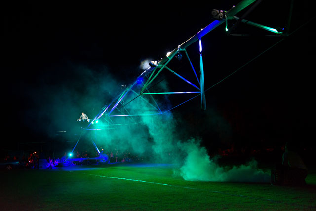 Vic McEwan on top of a 40-metre-long Pivot Irrigator, playing it like a giant cello, 2006. Artlands Regional Arts Conference and Festival, Dubbo NSW opening Ceremony. Image courtesy Vic McEwan.