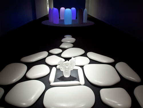 Mariko Mori. FOREGROUND: Flatstone, 2006. Ceramic stones and acrylic vase; 192 × 124 × 3 1/2 inches. Courtesy of SCAI THE BATHHOUSE, Tokyo and Sean Kelly, New York. BACKGROUND: Transcircle 1.1, 2004. Stone, Corian, LED, real-time control system; 132 3/8 inches diam., each stone 43 3/8 × 22 1/4 × 13 1/2 inches. Courtesy of The Mori Art Museum, Tokyo. Installation photograph: Richard Goodbody.